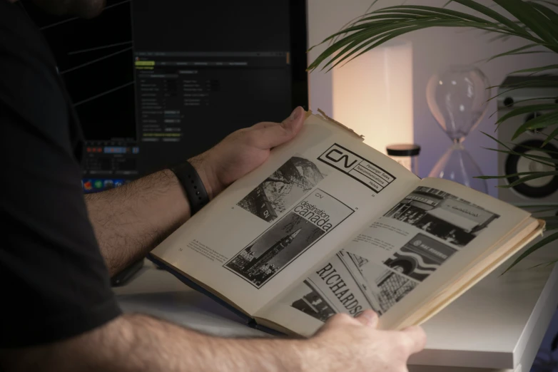 man is reading a book with two hands