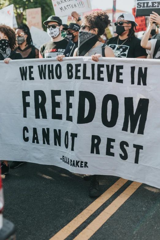 a group of protestors with a black sign