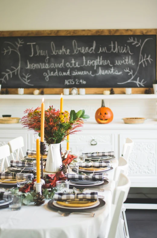 the table is set for a nice dinner in front of a chalk board with a chalkboard on it