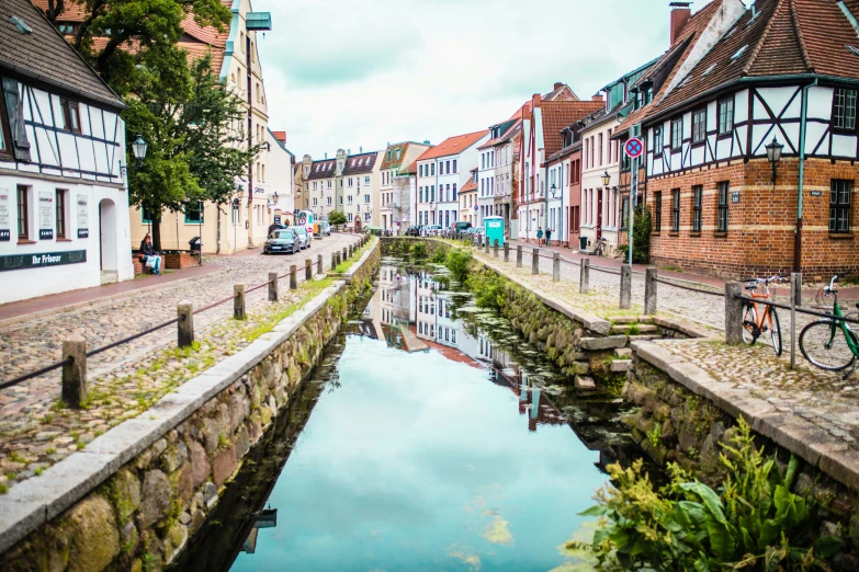 a canal runs between buildings with a few water