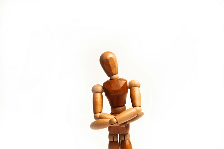 wooden toy figurine sitting on white ground with blank space