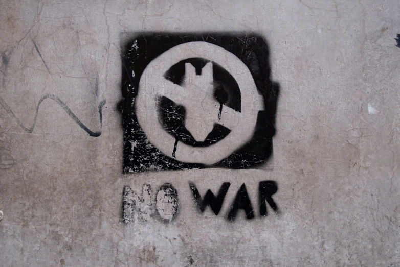 a spray painted wall with a symbol that says war no s