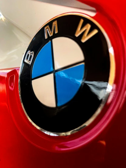 close up of an emblem on a red bmw car