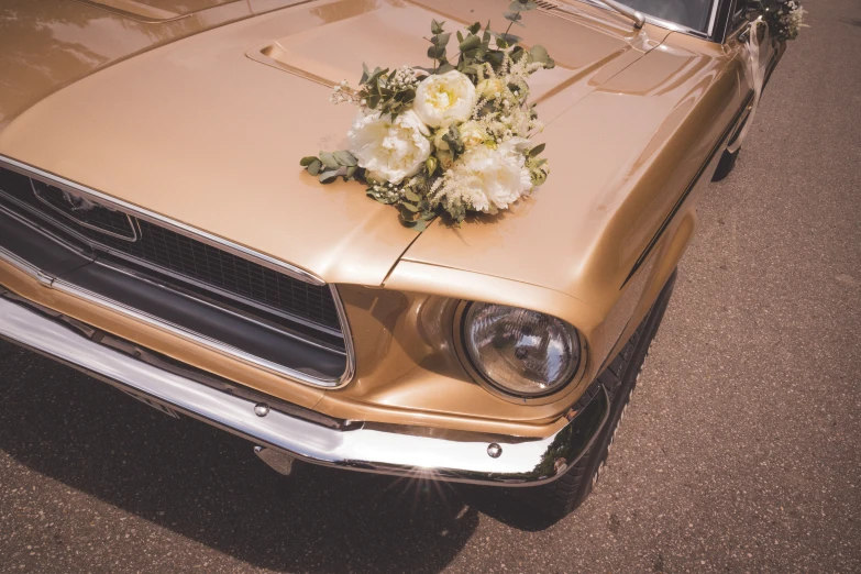 flowers decorate the hood of an old car