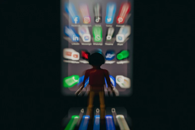 a small doll is standing in front of a futuristic phone