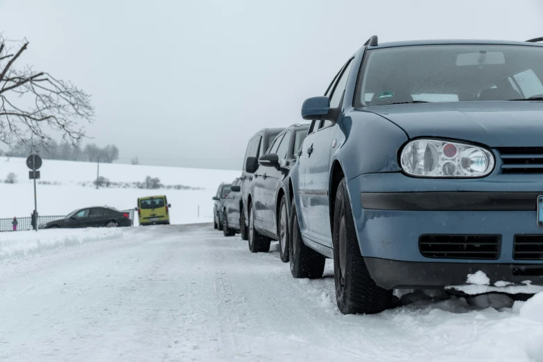 two vehicles parked in the snow at a curb