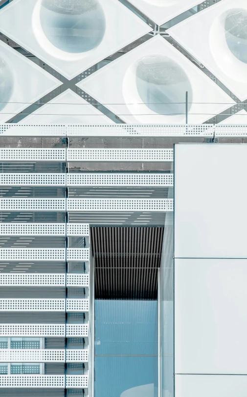 a building with white tiles and round lights above