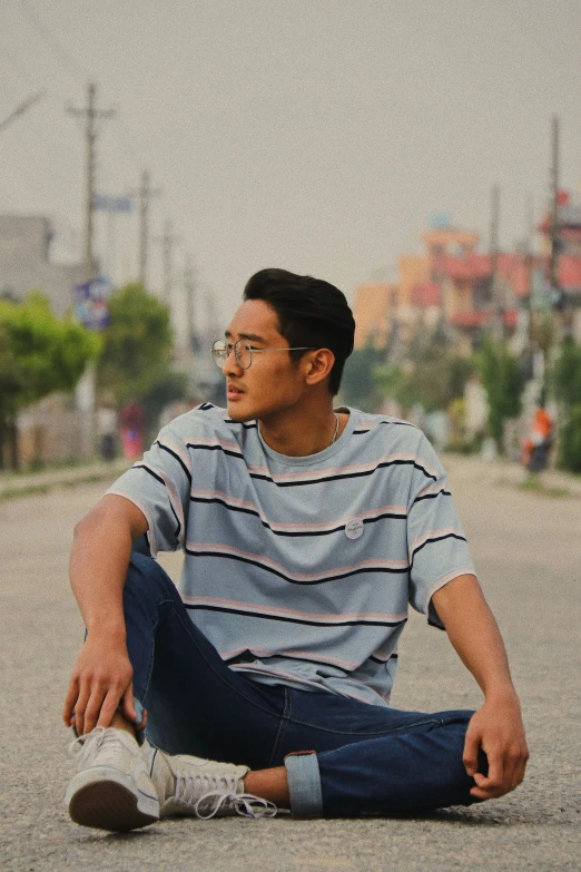 a man sitting in the street with his skateboard on