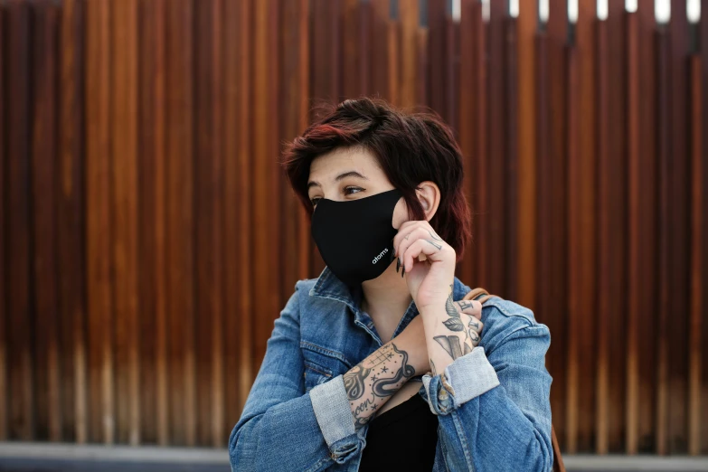a person with a face mask holding a phone up to their face