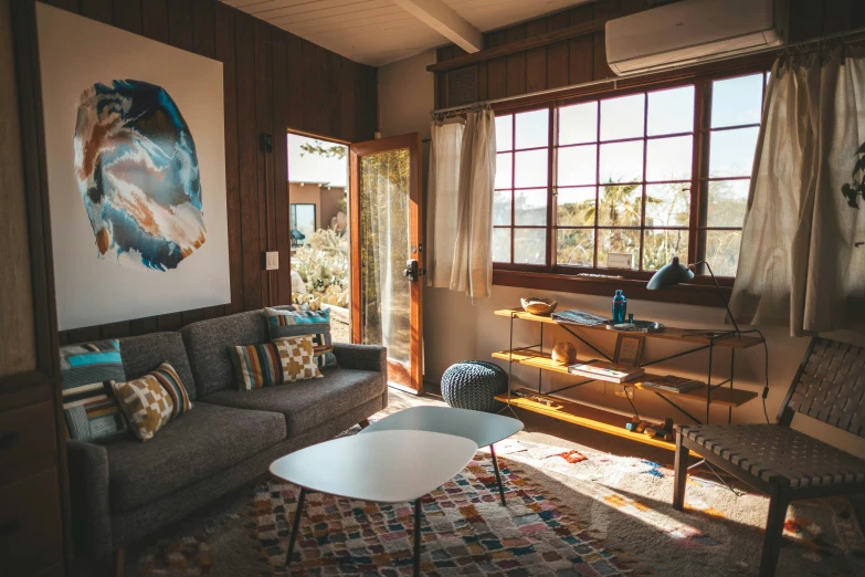 the sun shines through three windows into a room with several couches