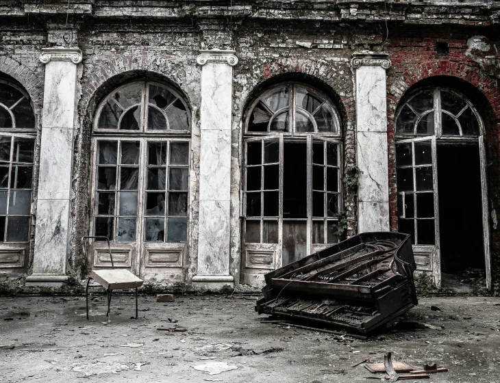 old piano outside in a ruined building