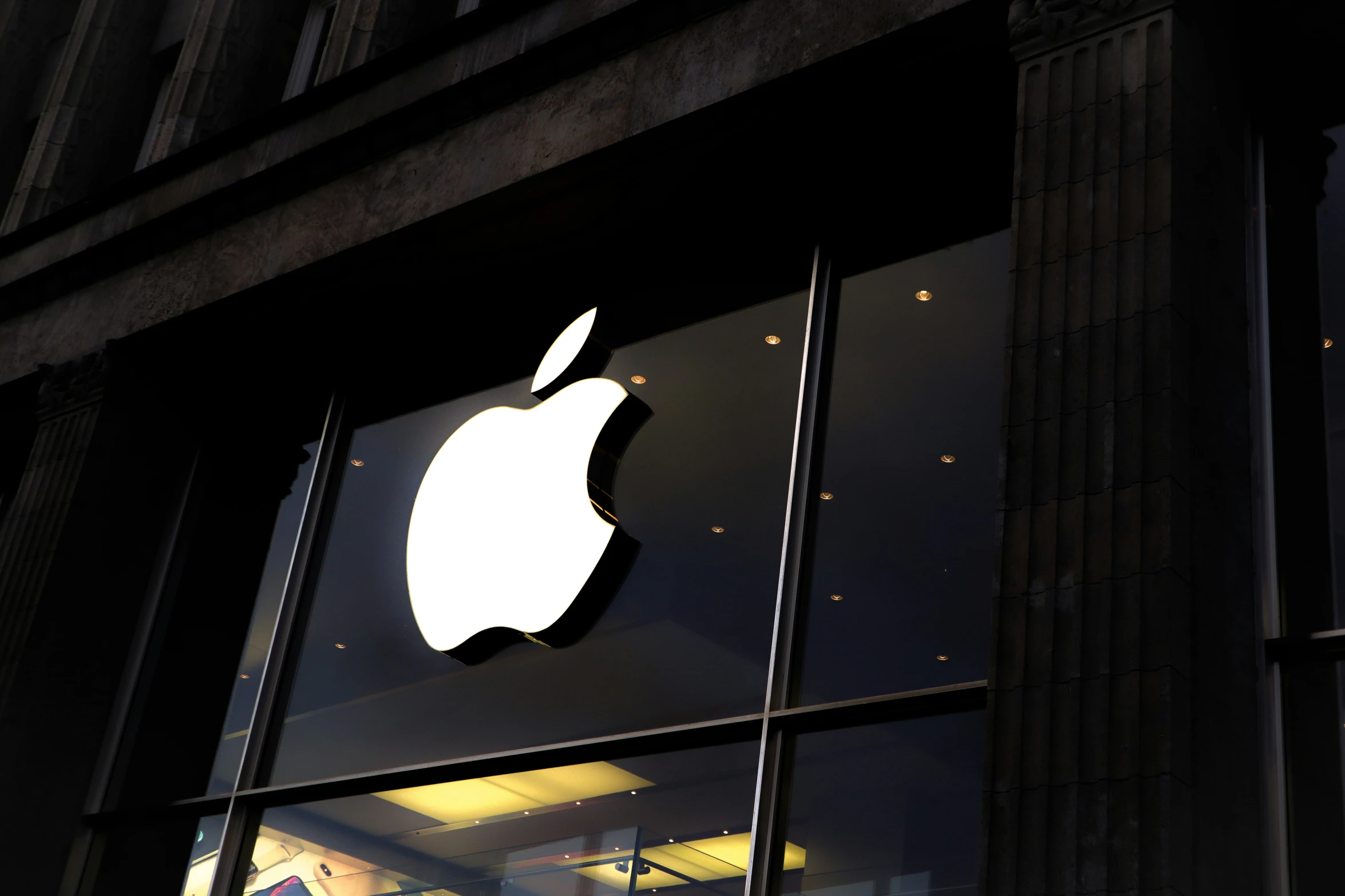 an apple store with it's logo reflected in its glass