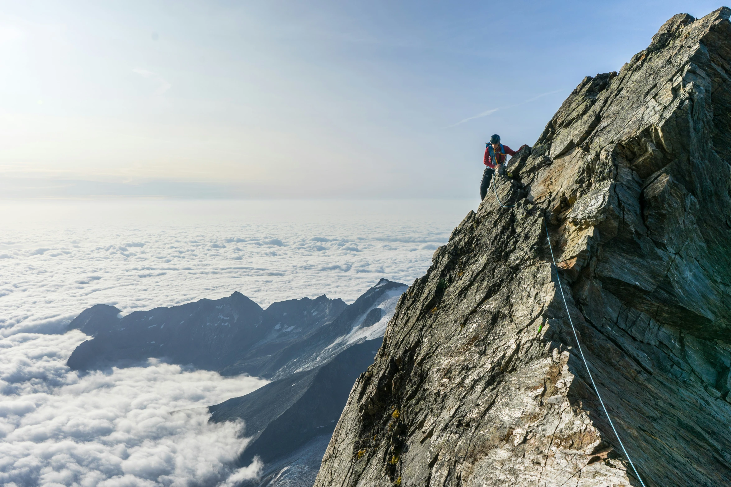 two people are standing on the edge of a mountain