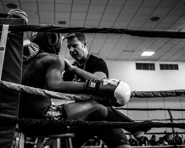 an umpire with an injured hand is talking to a professional boxer