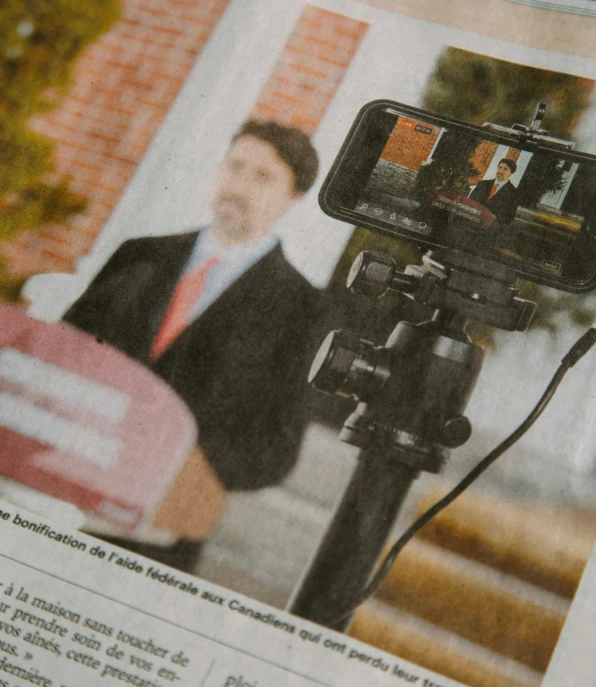 a news piece with a camera being filmed by a man