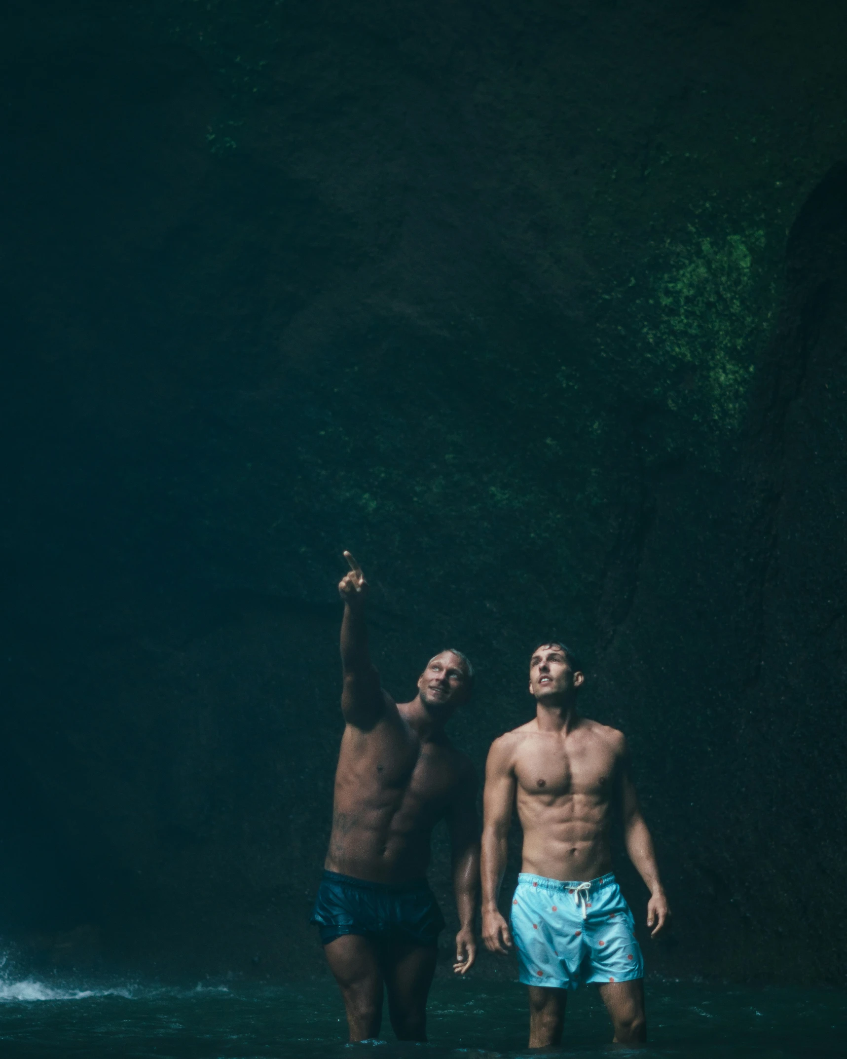 two men standing in the water of a body of water