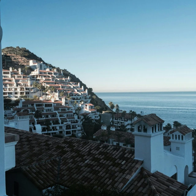 a large hill covered in many houses next to the ocean