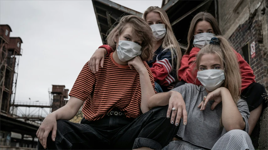 three women in face masks with their arms around them