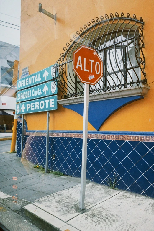 a corner sign on an elo street side with a building and another side