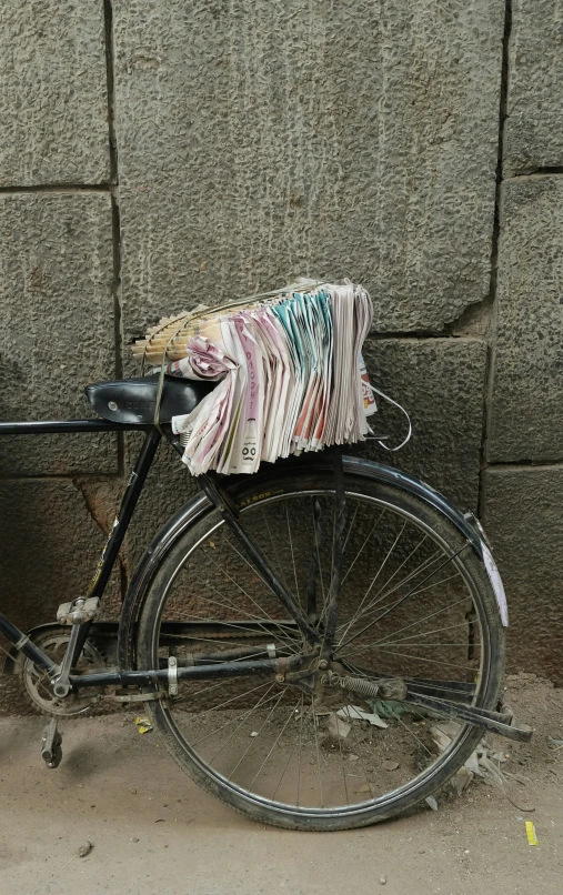 an old bicycle leaning against a stone wall