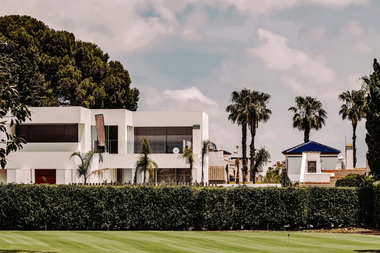 a large building next to palm trees and shrubs