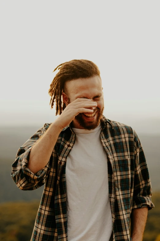 a bearded man holding his hand to his face