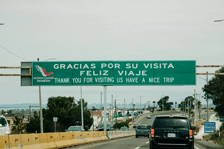 a green and white sign reading gracias por su vista, feiliz vaje and thank you visiting us have a nice trip