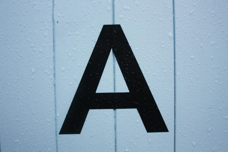 the side of a wall with a sign that has an a on it