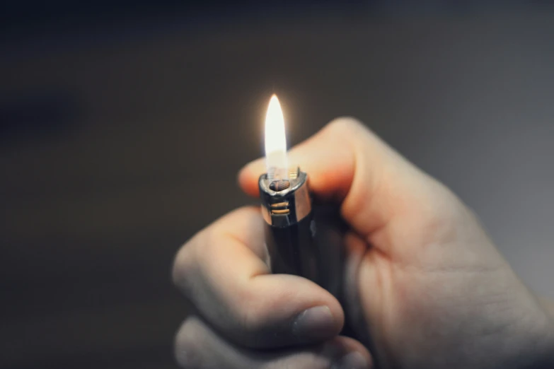 someone holding a lighter with the light turned on