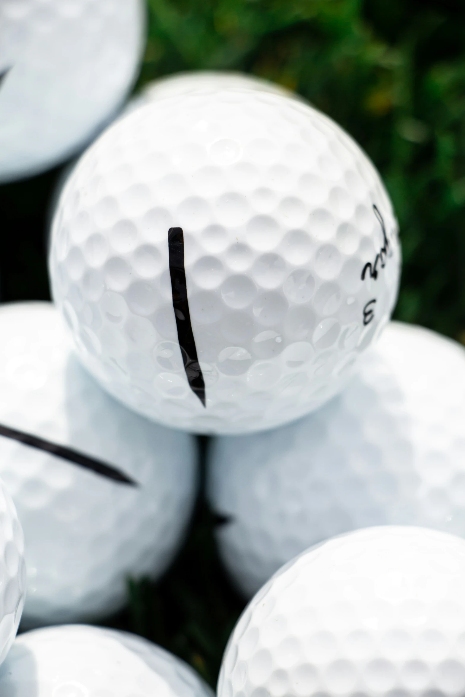 several white balls with black marker marks stacked up