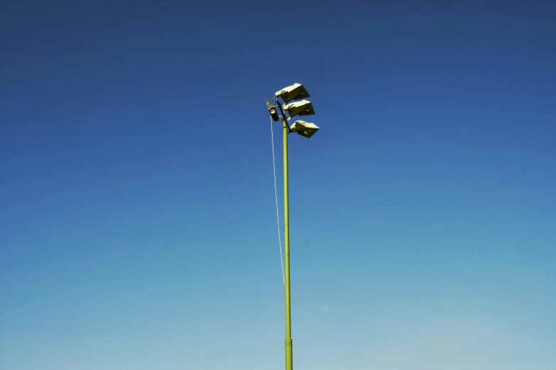 two street lights in the blue sky, one with snow on top