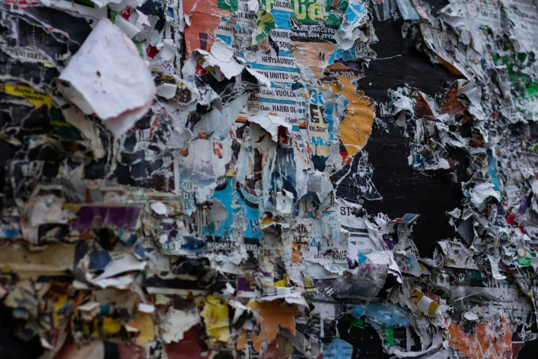 several newspapers and papers are strewn up on the wall