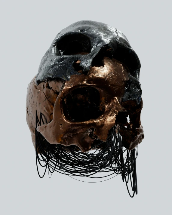 a metallic skull that is hanging from a wire