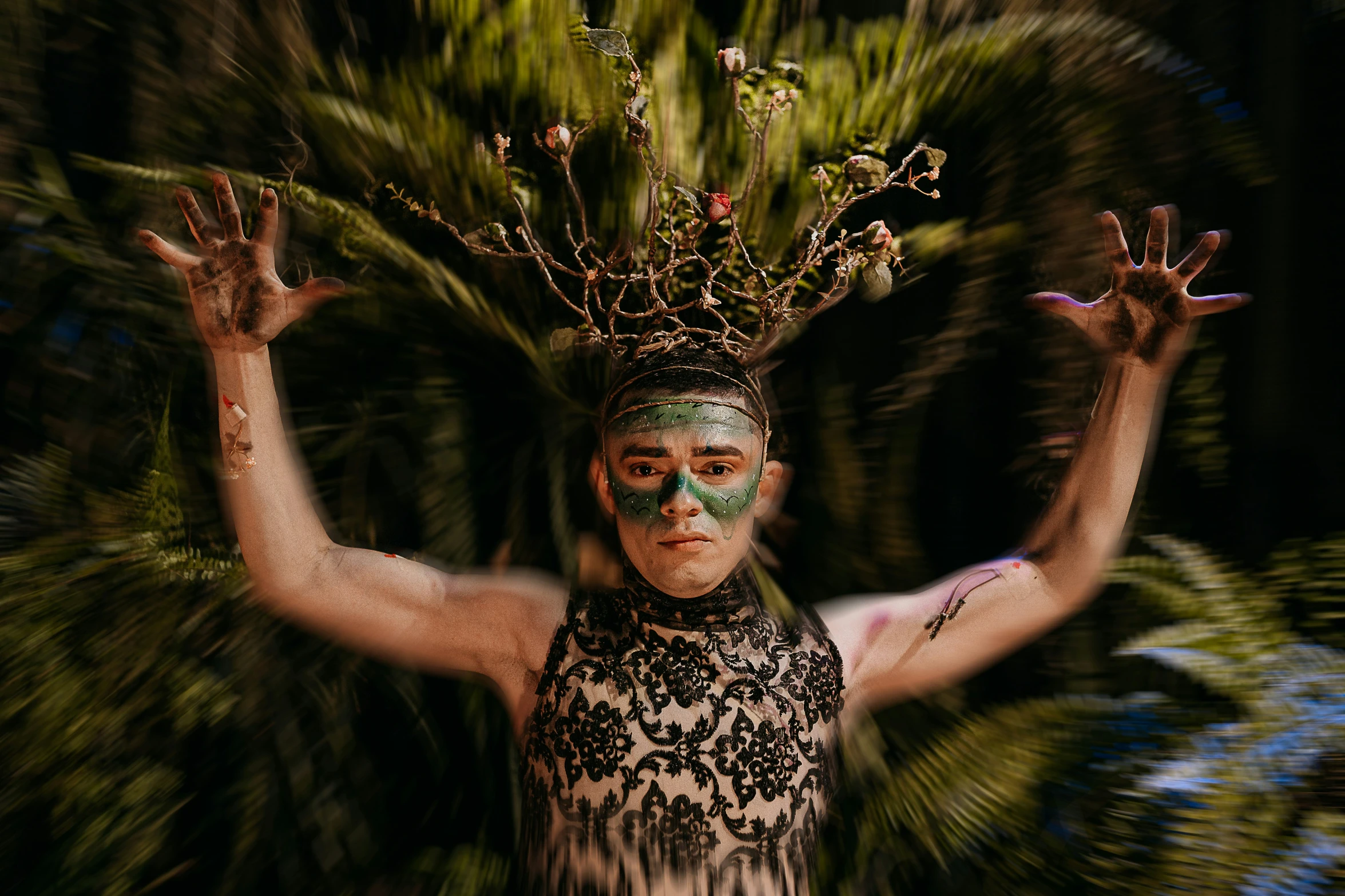 a girl in white makeup and black headpiece with plant crowns on her head