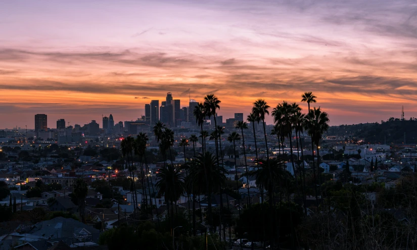 the sun is setting over a city skyline