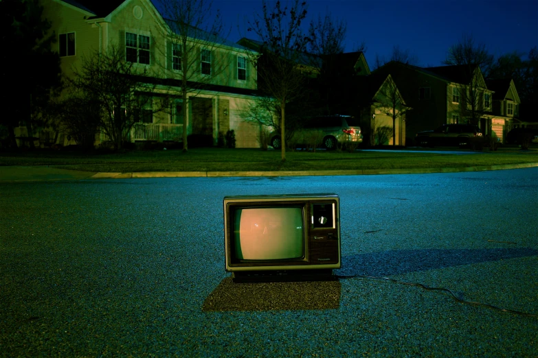 a tv sitting on the ground in a neighborhood