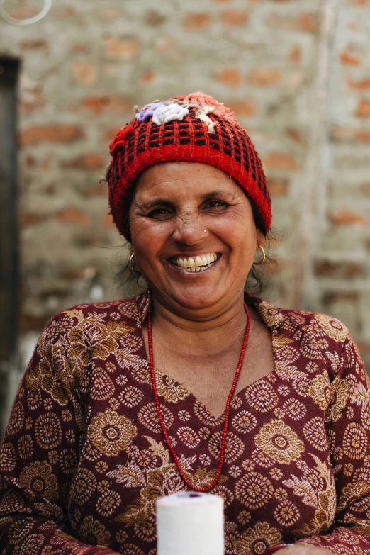 an older woman is smiling and holding a coffee cup