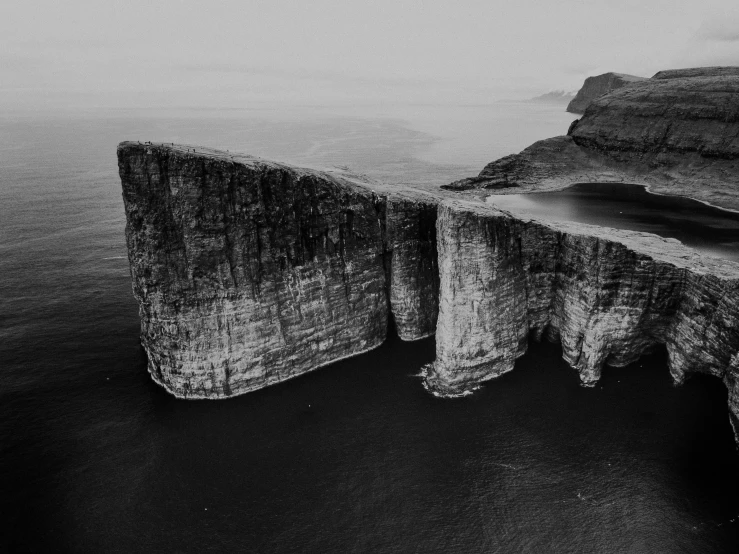 a cliff with water in the middle and a black and white po of it