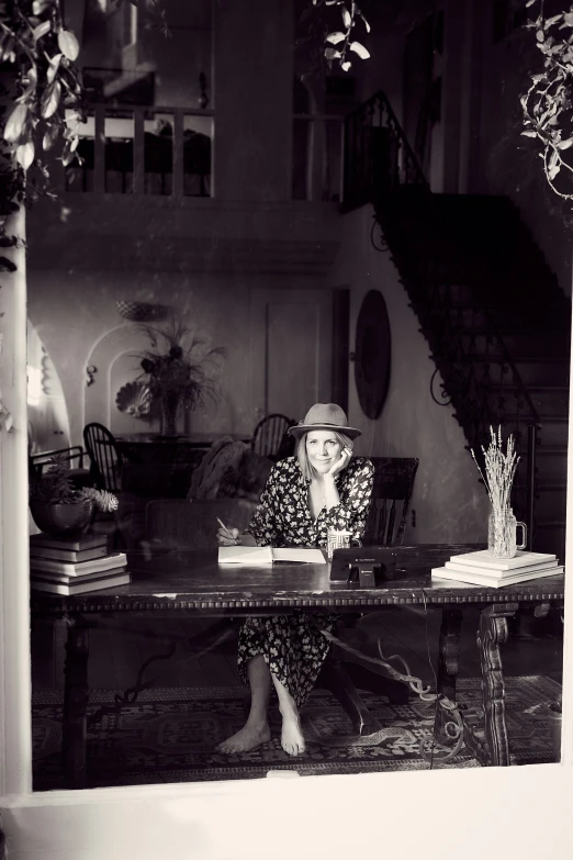 woman sitting at a table in a house with a glass door looking into the dining room