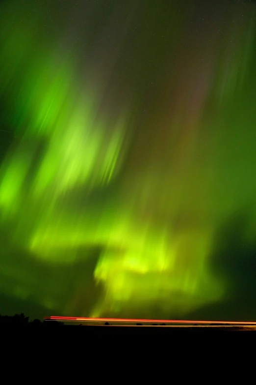 a view of green lights shining on the night sky