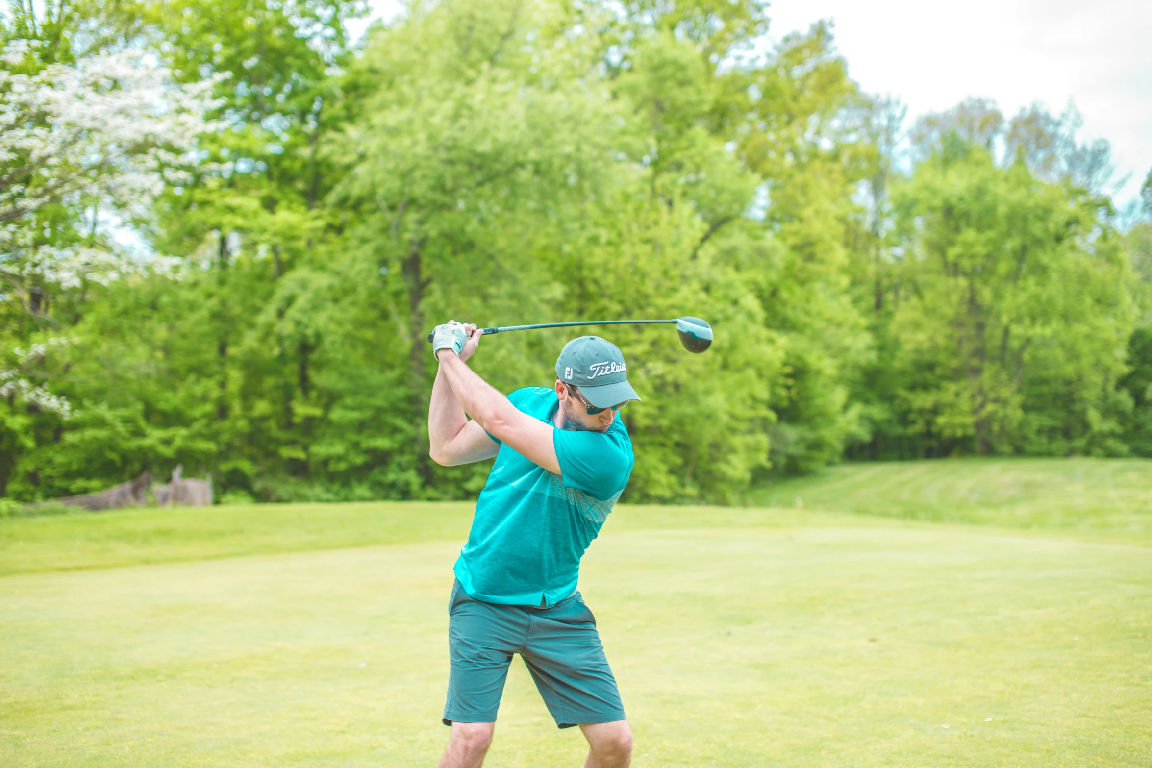 a man hitting a golf ball with a driver