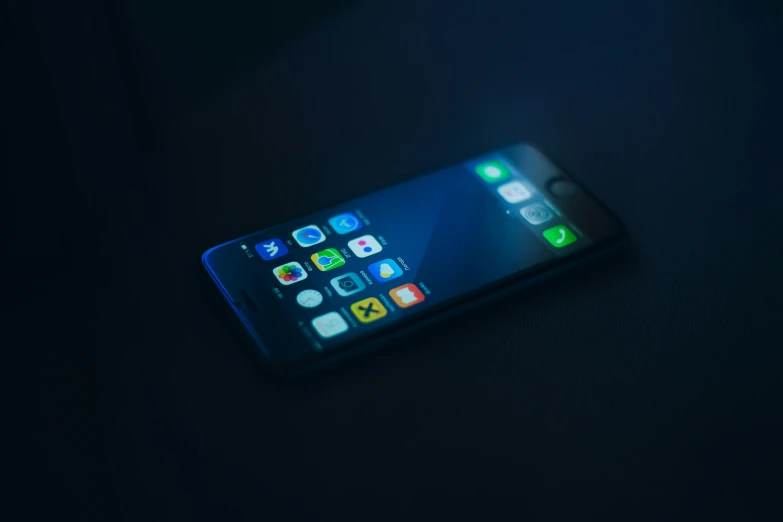 a cell phone lit up at night sitting on a desk