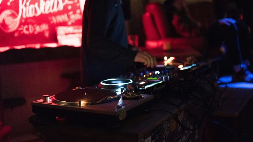 the dj mixing music in a dark nightclub