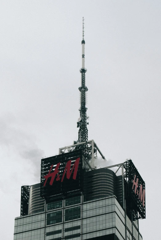 the top of a skyscr, with a sky scr and radio tower in the background