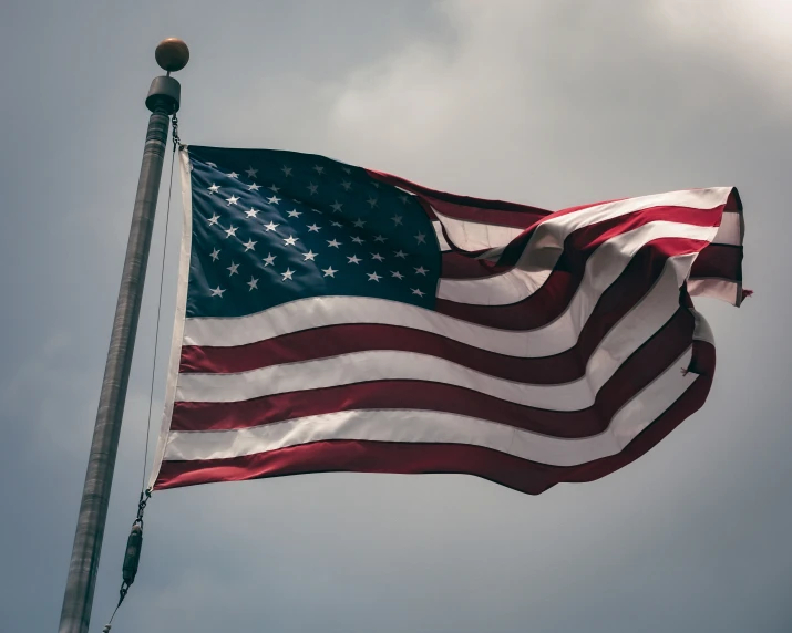 a flag waving in the wind while a clock looks up