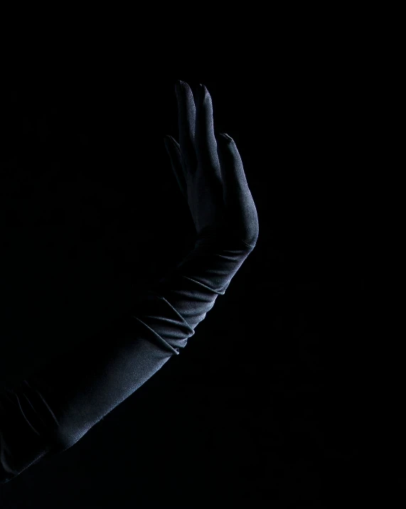 a person in the dark holding up their hands