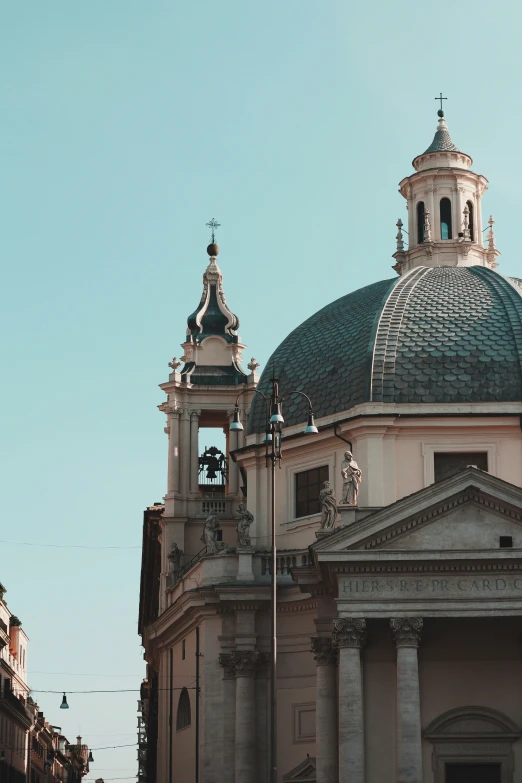 two large buildings on the street one has a bell and another has domes