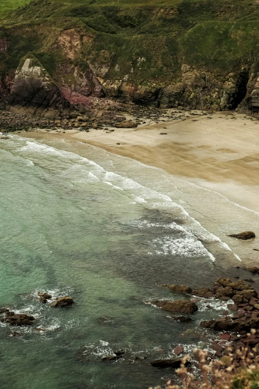 an aerial s of a beach and rocky cliff