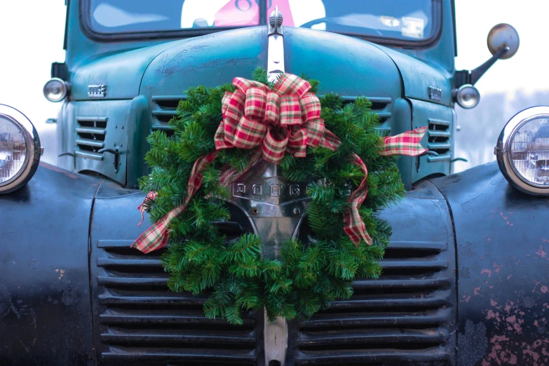 a front of a car with a wreath on the hood