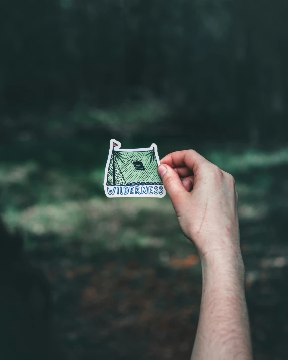 a hand holding a sticker that says i do not have to give up trees